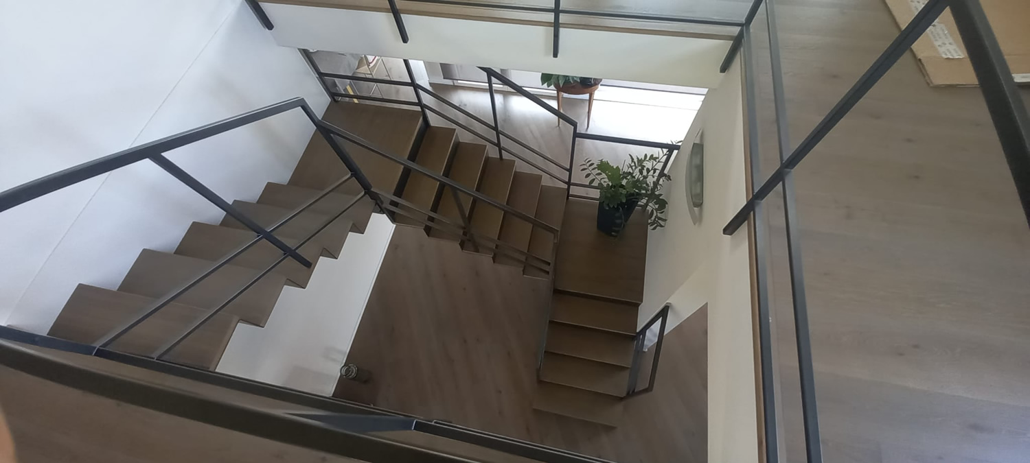Scala abitazione interna in ferro cosciale sagomato con alzata chiusa e ringhiera